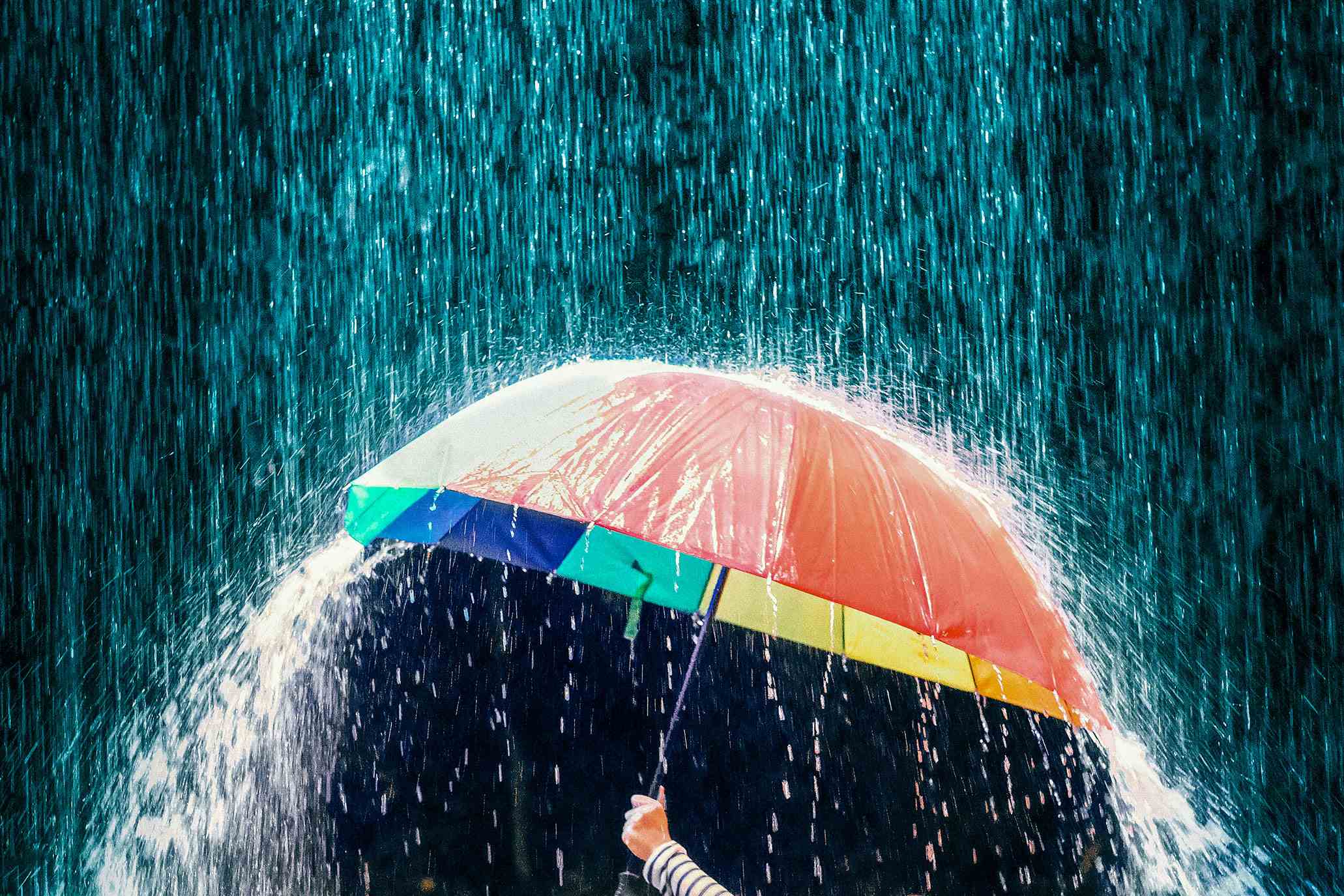 Abgeschnittene Hand mit Regenschirm bei Regen