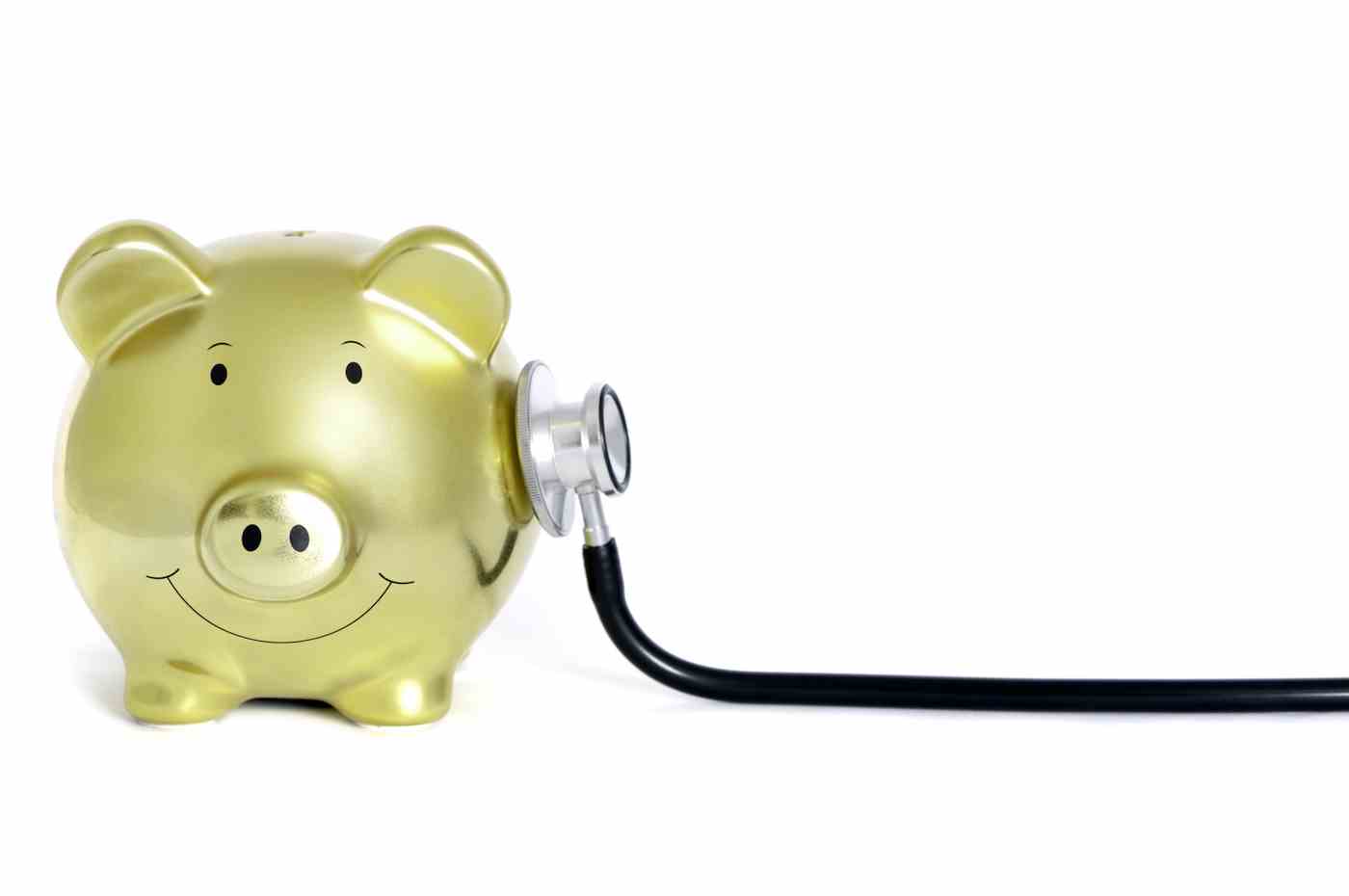 Konzeptionelles Bild eines goldenen Sparschweins und Stethoskops isoliert auf reinem Weiß, selektiver Fokus auf das Sparschwein