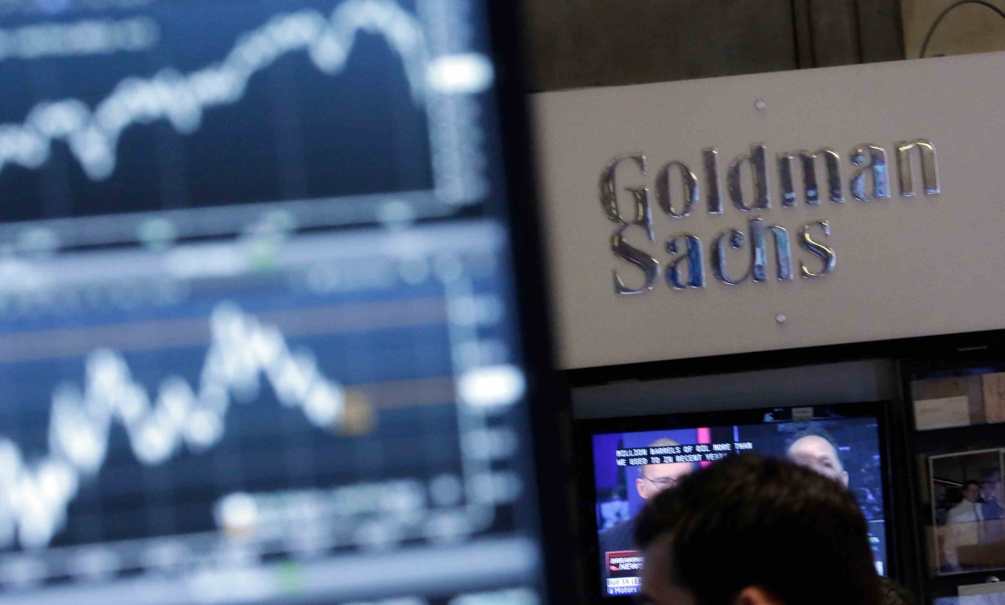 Ein Bild eines Bildschirms in einem Handelsposten auf dem Parkett der New Yorker Börse ist dem Stand von Goldman Sachs gegenübergestellt