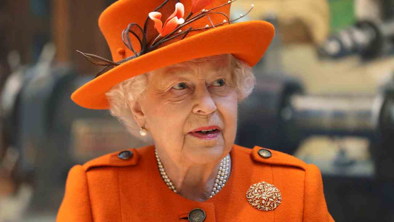 Eine auffällige Kleidungsfarbe mit Hut, Perlenkette, Brosche und ihrem Clarins-Lippenstift: So lässt sich die Königin immer anziehen.