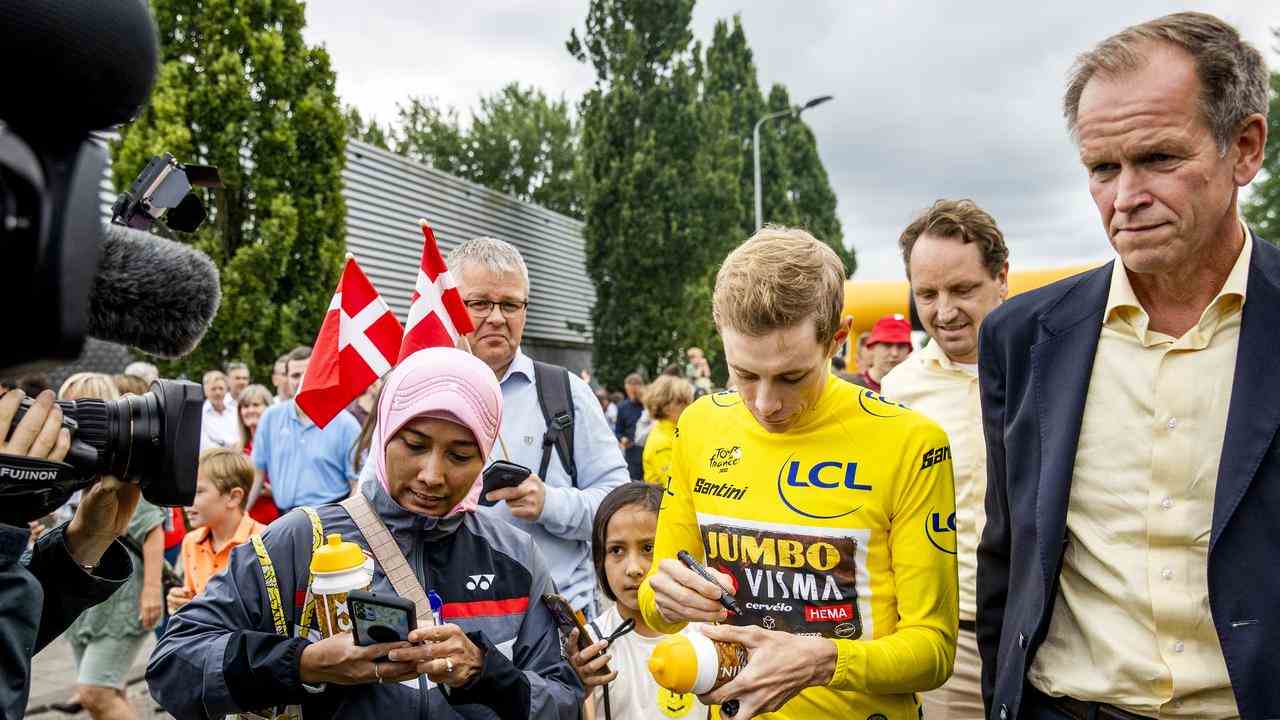 Die Jumbo-Regisseure Richard Plugge (r) und Merijn Zeeman (m) sehen zu, wie Vingegaard Autogramme gibt.