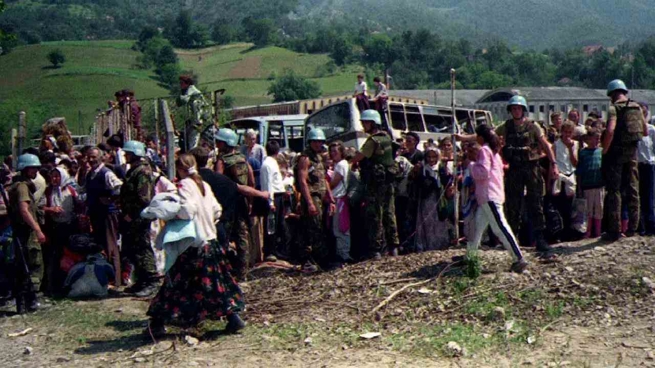 Niederländische UN-Soldaten bewachen Flüchtlinge in Potocari, die nach dem Fall von Srebrenica am 12. Juli 1995 auf den Abtransport warten.