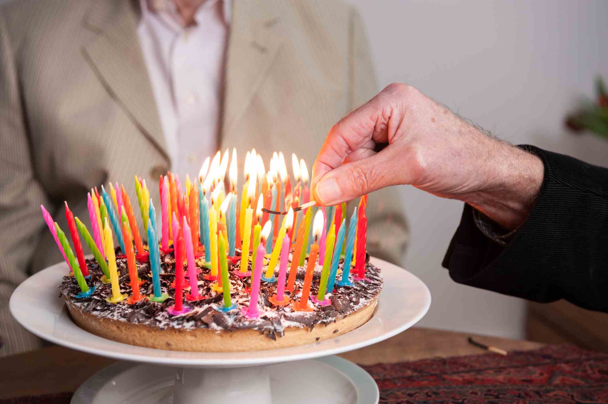 Person zündet 93 Kerzen auf einem Kuchen an;  Longevity Tech-Investorenumfrage