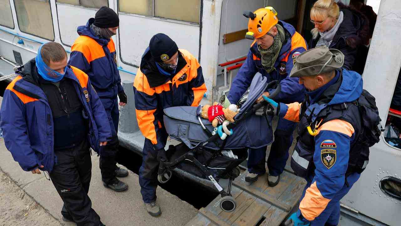 Ein Kinderwagen wird nach Verlassen von Cherson von der Fähre gehoben.