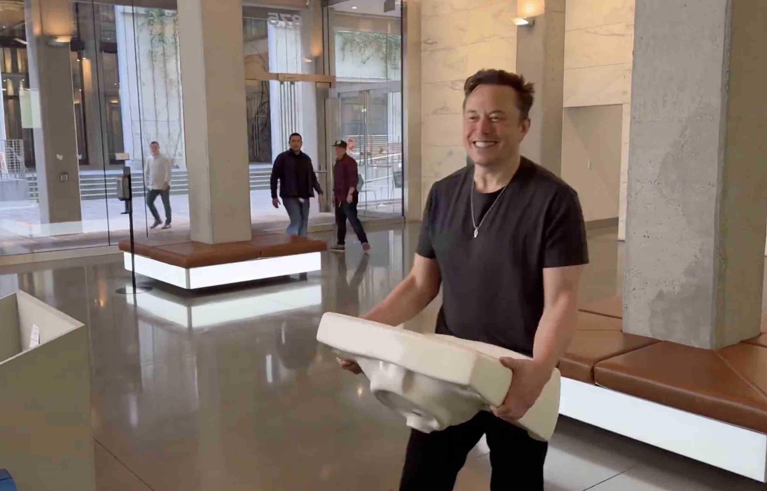 Elon Musk trägt ein Waschbecken ins Twitter-Hauptquartier