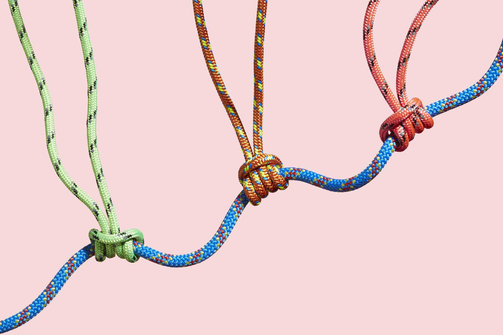 Drei farbige Seile, die ein größeres Seil stützen