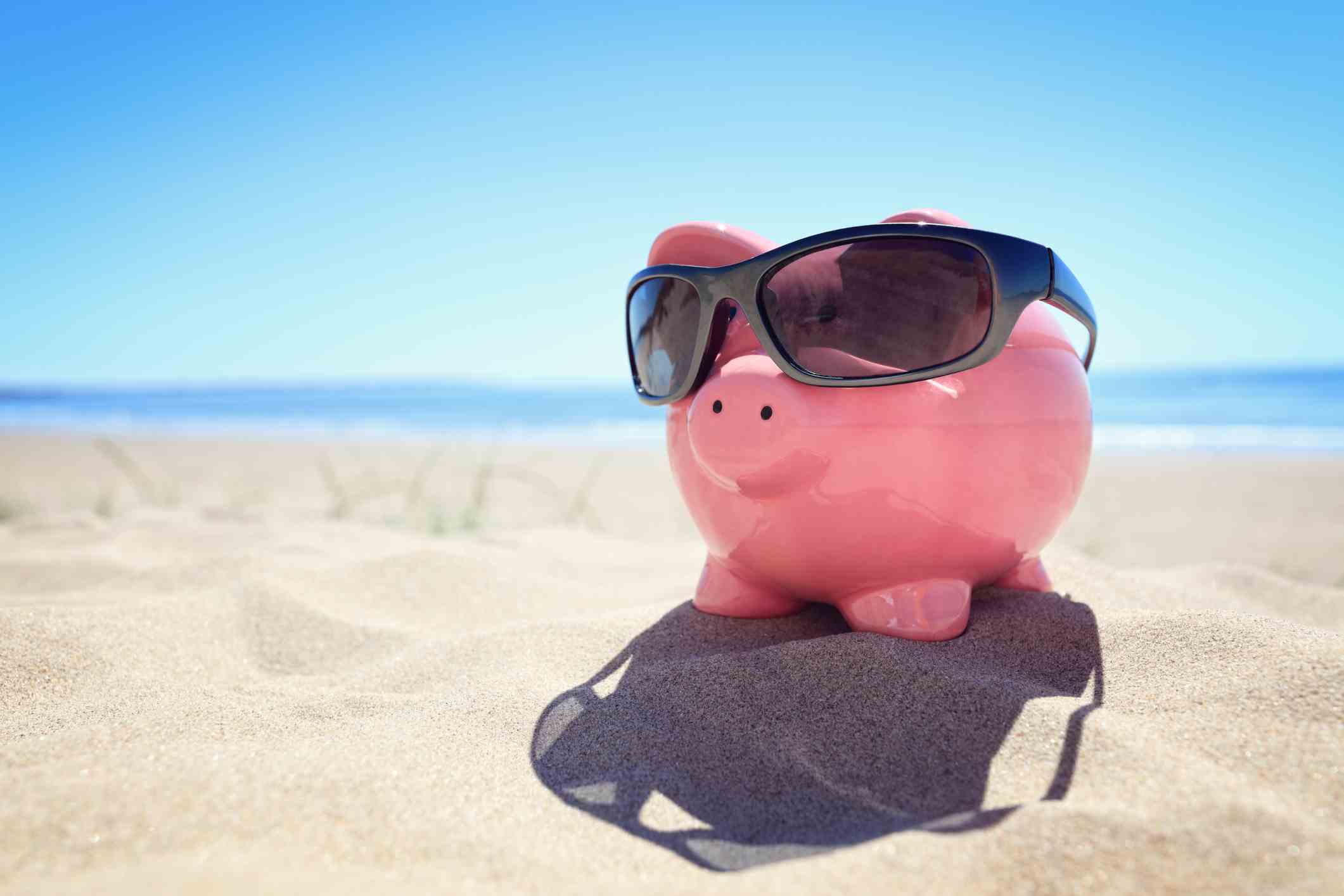 Sparschwein mit Sonnenbrille am Strand am Meer
