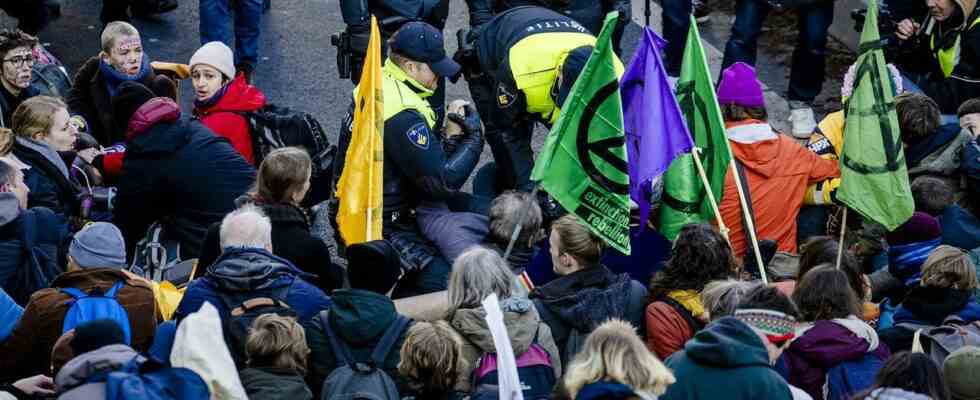Die Polizei versucht Hunderte von Klimaaktivisten mit Muehlen und Cola