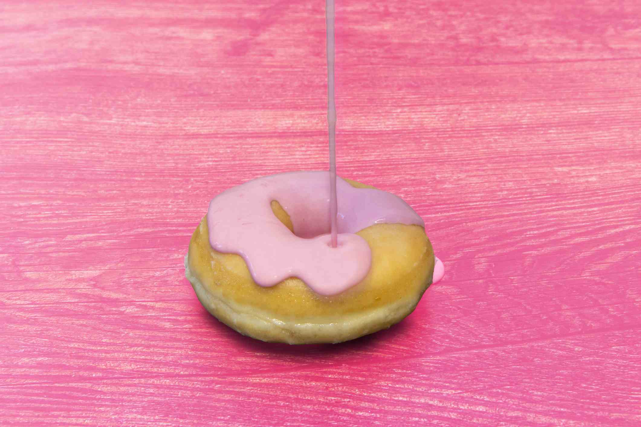 Donut mit rosa Toppings auf einem rosa Tisch