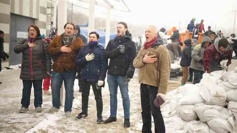 Une chorale chante l'hymne national ukrainien dans le vent et la neige