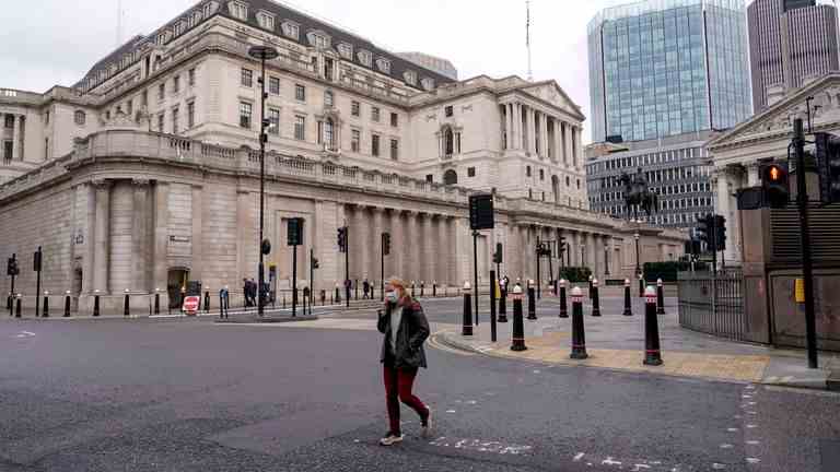 Une personne porte un masque facial alors qu'elle traverse une rue devant la Banque d'Angleterre Image: AP