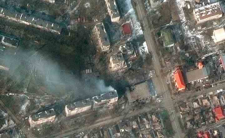 Cette image satellite fournie par Maxar Technologies montre des immeubles d'habitation en feu dans la rue Zelinskovo, dans l'ouest de Marioupol, en Ukraine, le samedi 12 mars 2022. (Image satellite ©2022 Maxar Technologies via AP)