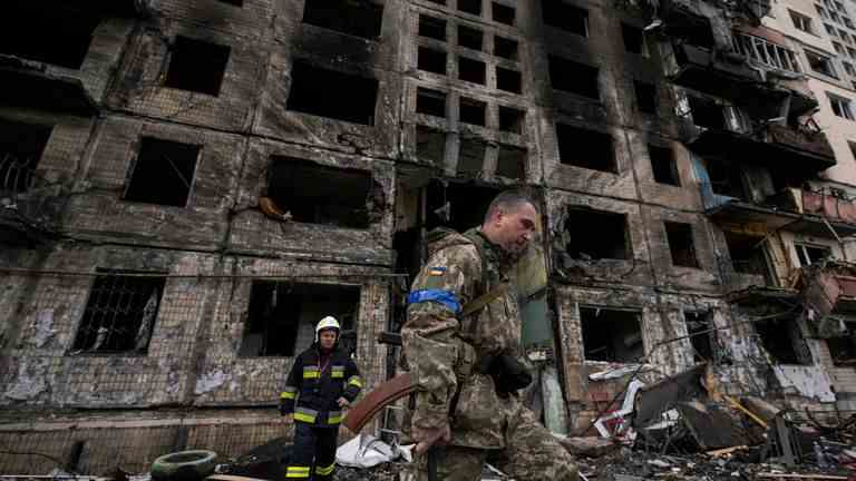 Des soldats et des pompiers ukrainiens fouillent un bâtiment détruit après un attentat à la bombe à Kiev.  Image : AP