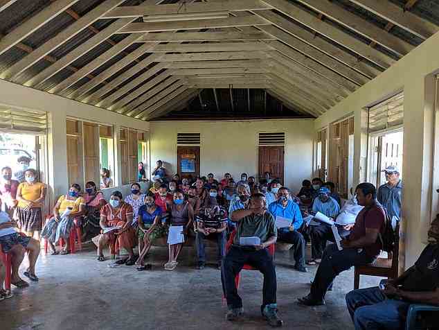 La visite, y compris l'atterrissage de l'hélicoptère, aurait été organisée par des responsables locaux.  Sur la photo: la réunion communautaire au Belize