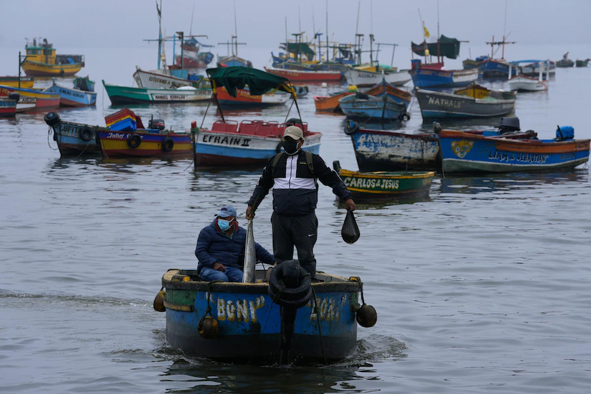 Un homme se tient dans un bateau et tient des ordures dans sa main.