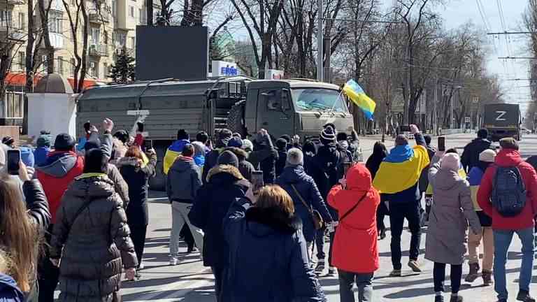 Des manifestants face à des véhicules militaires russes à Kherson