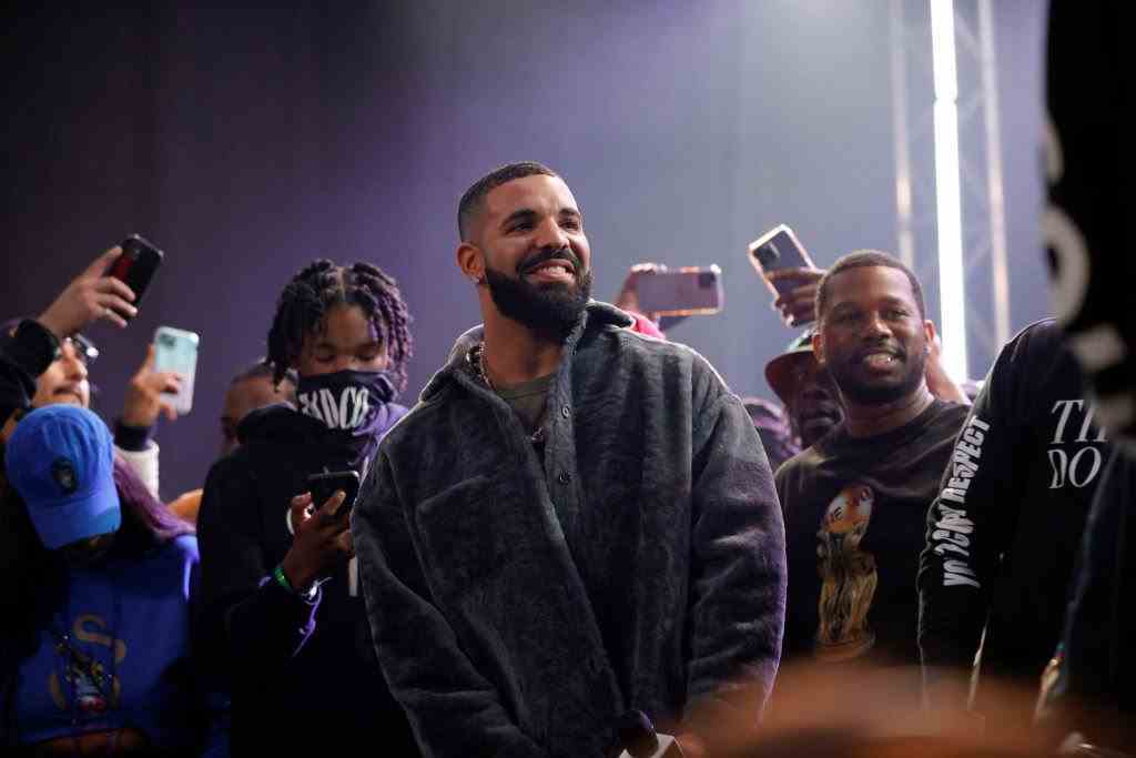 Drake souriant entouré de fans