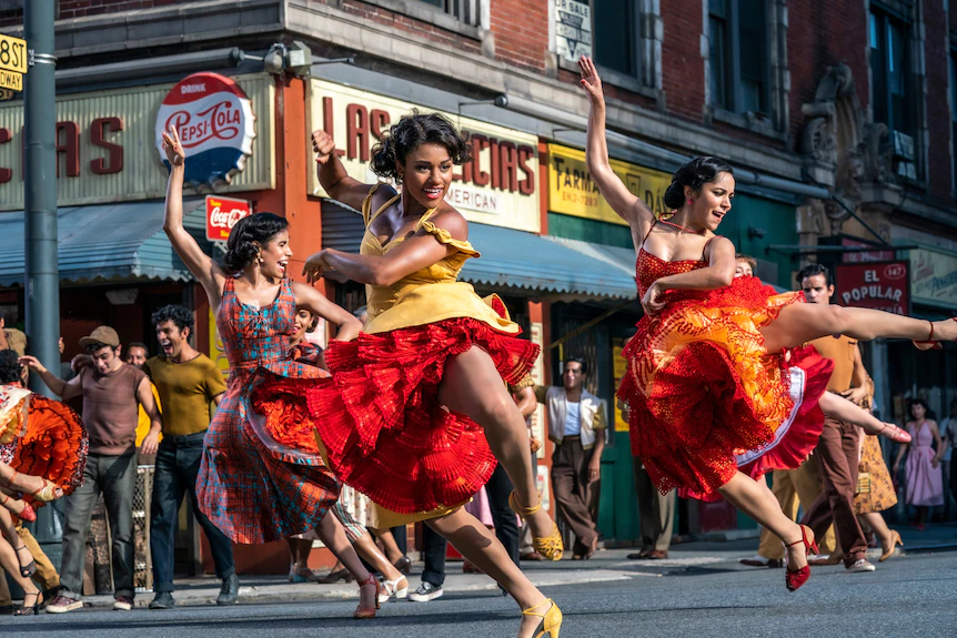 Trois femmes portoricaines vêtues de robes colorées se produisent dans une routine de danse dans les rues de New York.