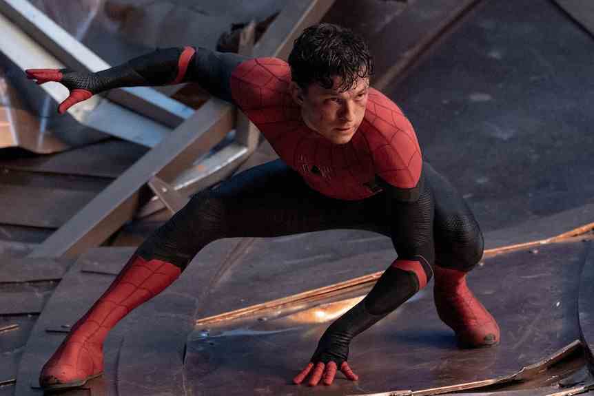 Un Spider-Man démasqué s'accroupit dans une fente basse, une main sur le sol entre ses jambes et l'autre en l'air derrière lui