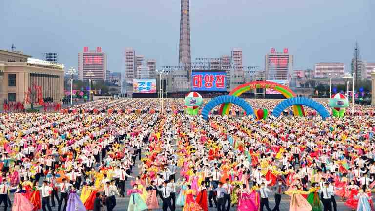 Les gens dansent lors de la célébration de l'anniversaire du défunt fondateur de l'État Kim Il Sung sur la place Kim Il Sung à Pyongyang, en Corée du Nord, le vendredi 15 avril 2022.  (Kyodo News via AP)