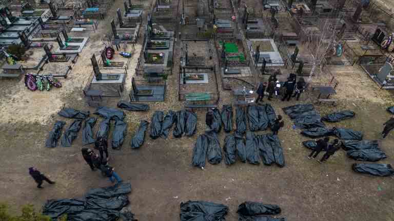 Des policiers travaillent sur le processus d'identification suite au meurtre de civils à Bucha avant d'envoyer les corps à la morgue de la périphérie de Kiev, en Ukraine, le mercredi 6 avril 2022.  (AP Photo/Rodrigo Abd)