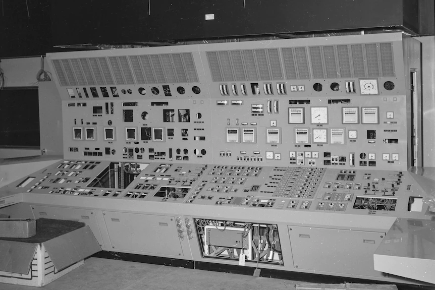 Une photo en noir et blanc d'une grande unité de commutation recouverte de cadrans et d'interrupteurs.