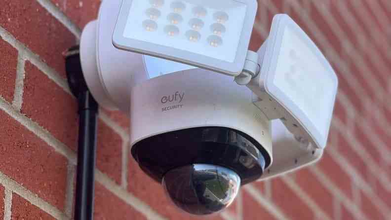 Système de surveillance blanc avec caméras intégrées et lumières sur le mur de briques.