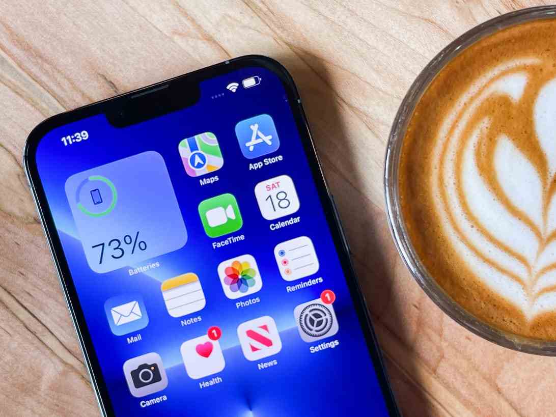 iPhone allongé sur une table à côté d'un café au lait