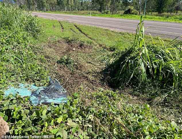 Le site de l'accident à l'ouest de Townsville, avec des traces de dérapage encore visibles sur la route et des fragments brisés d'une fenêtre au premier plan