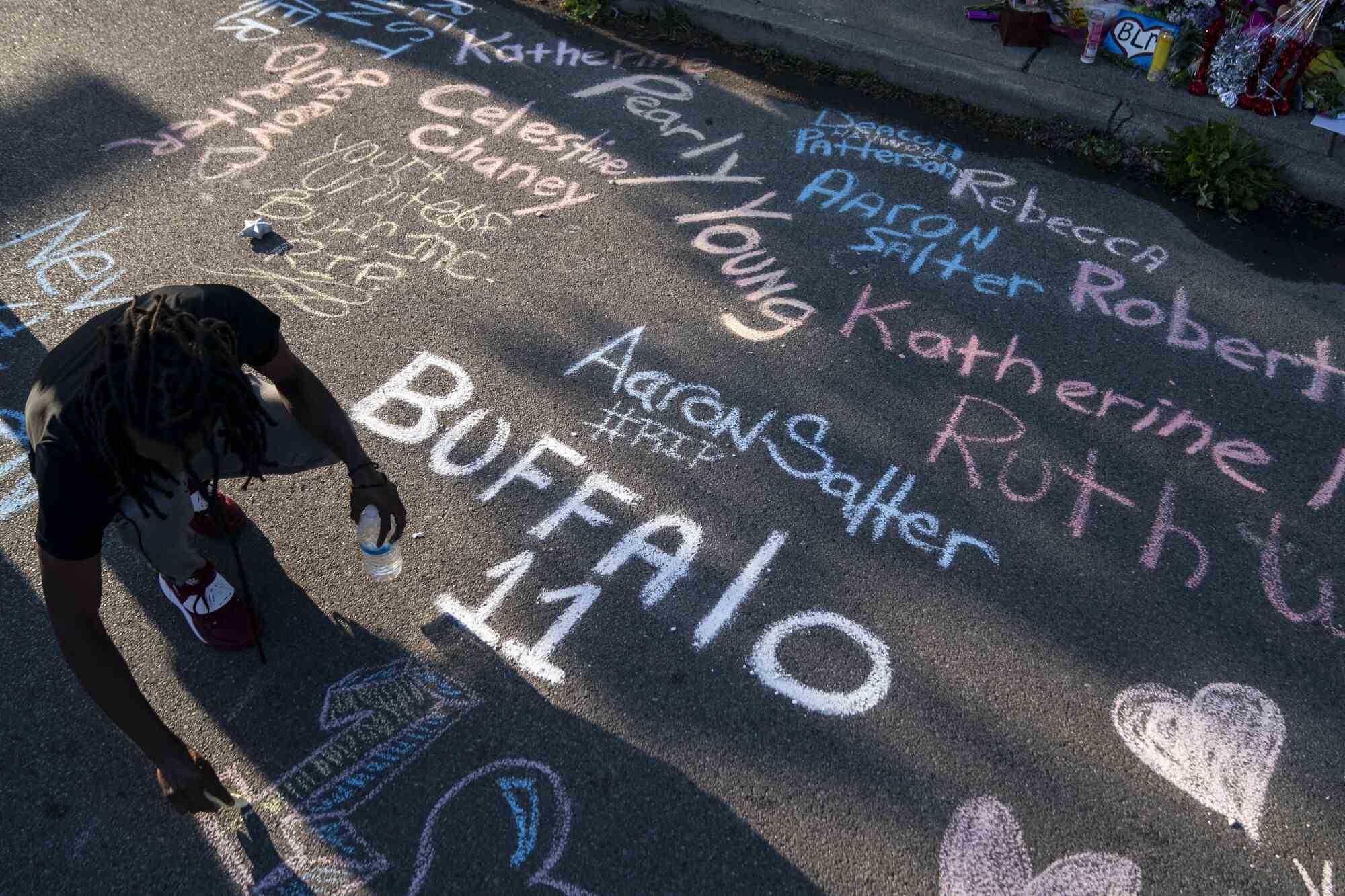 Des noms écrits à la craie sur le trottoir