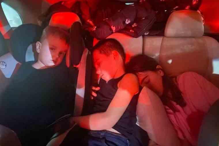 Les réfugiés ukrainiens Danylo (3 ans), Lev (7 ans) et Vasilisa Halytska (11 ans) ont dormi dans la voiture pendant plusieurs jours alors que leur famille tentait de quitter l'Ukraine.