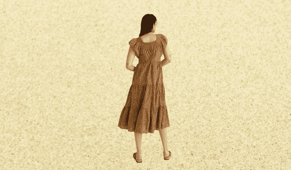 Le dos d'une femme portant une robe de style prairie à motifs marron