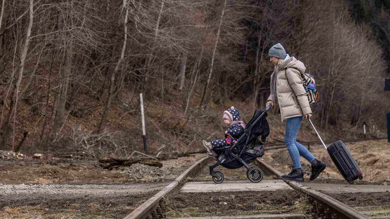 Une réfugiée ukrainienne avec son enfant traverse la frontière polonaise.