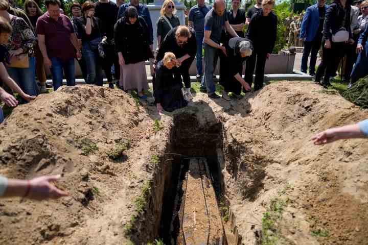 Des proches du colonel de l'armée Oleksander Makhachek pleurent lors de ses funérailles à Jytomyr, en Ukraine, le vendredi 3 juin 2022. 