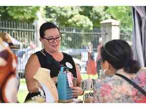 Heidi Steinhoff de Windsor, connue des invités de The Beadiva, aide un client à Art in the Park à Willistead Park le samedi 4 juin 2022.