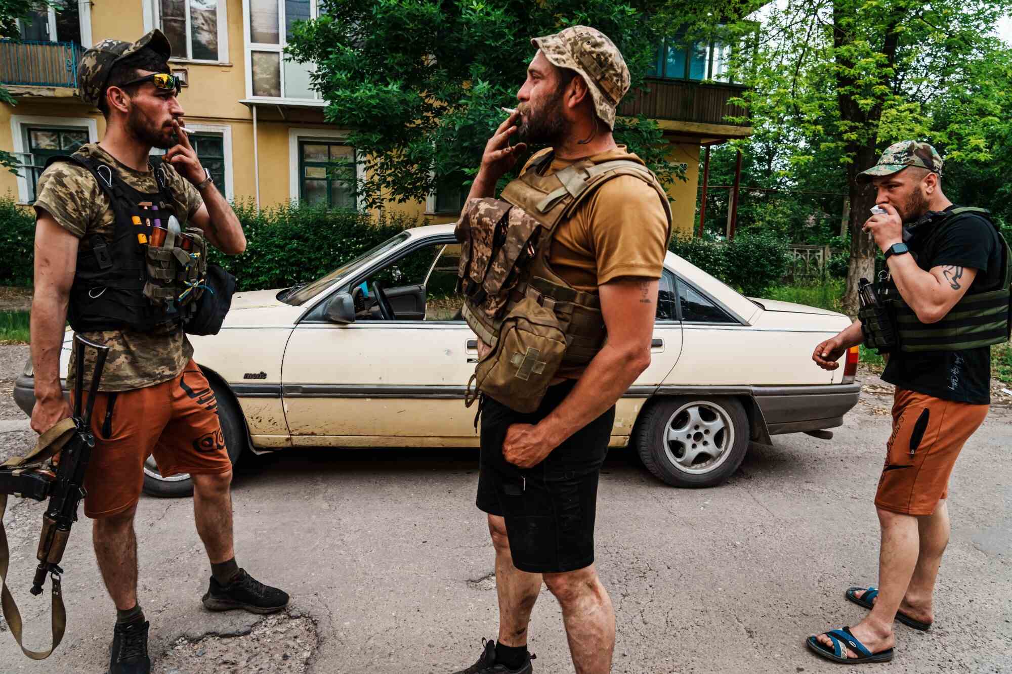 Des hommes armés fument des cigarettes près du centre-ville de Seversk, en Ukraine.