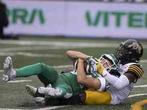 Le receveur éloigné des Roughriders de la Saskatchewan Jakob Prall (84) attrape le ballon alors que le défenseur des Tiger Cats de Hamilton Alden Darby (22) marque lors du match d'ouverture des Riders au Mosaic Stadium le samedi 11 mai.