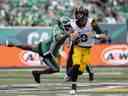 Le défenseur des Roughriders de la Saskatchewan AC Leonard, à gauche, a pris le chandail du quart-arrière des Tiger-Cats de Hamilton, Dane Evans, au Mosaic Stadium, samedi.