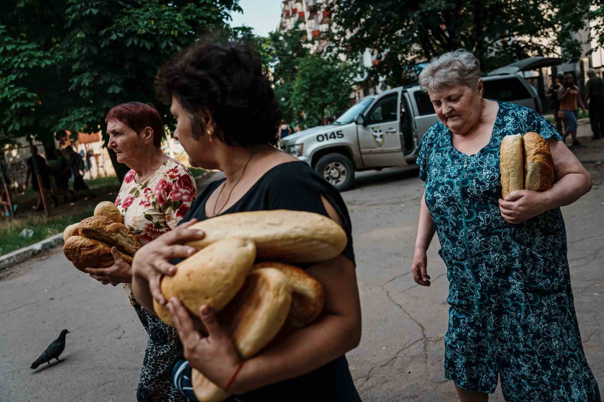 Des résidents transportent des provisions qui leur ont été données par des policiers à Lysychansk, en Ukraine.