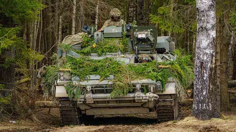 Des soldats britanniques montent à bord de véhicules blindés lors de manœuvres en Estonie lors de l'exercice Bold Dragon de l'OTAN