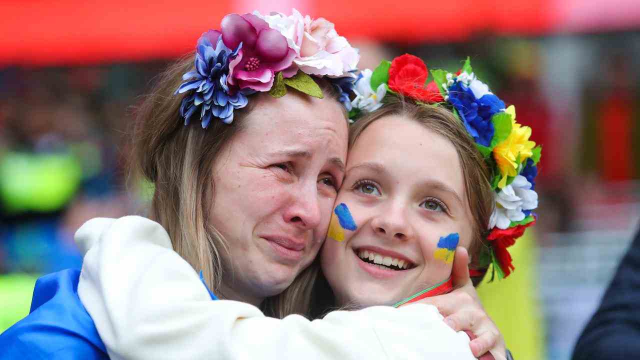 Une supportrice ukrainienne est réconfortée après que son pays ait raté la Coupe du monde.