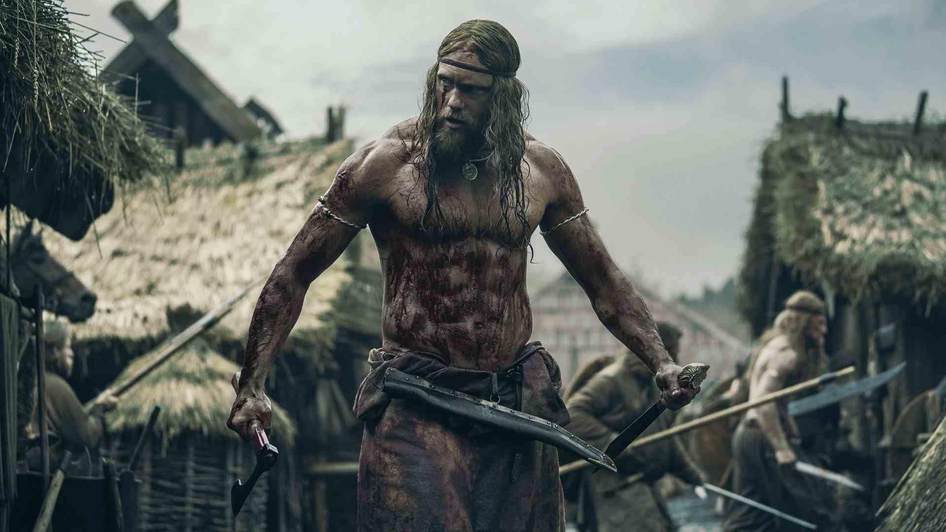 Un Viking se tient ensanglanté au milieu d'un raid dans un village.
