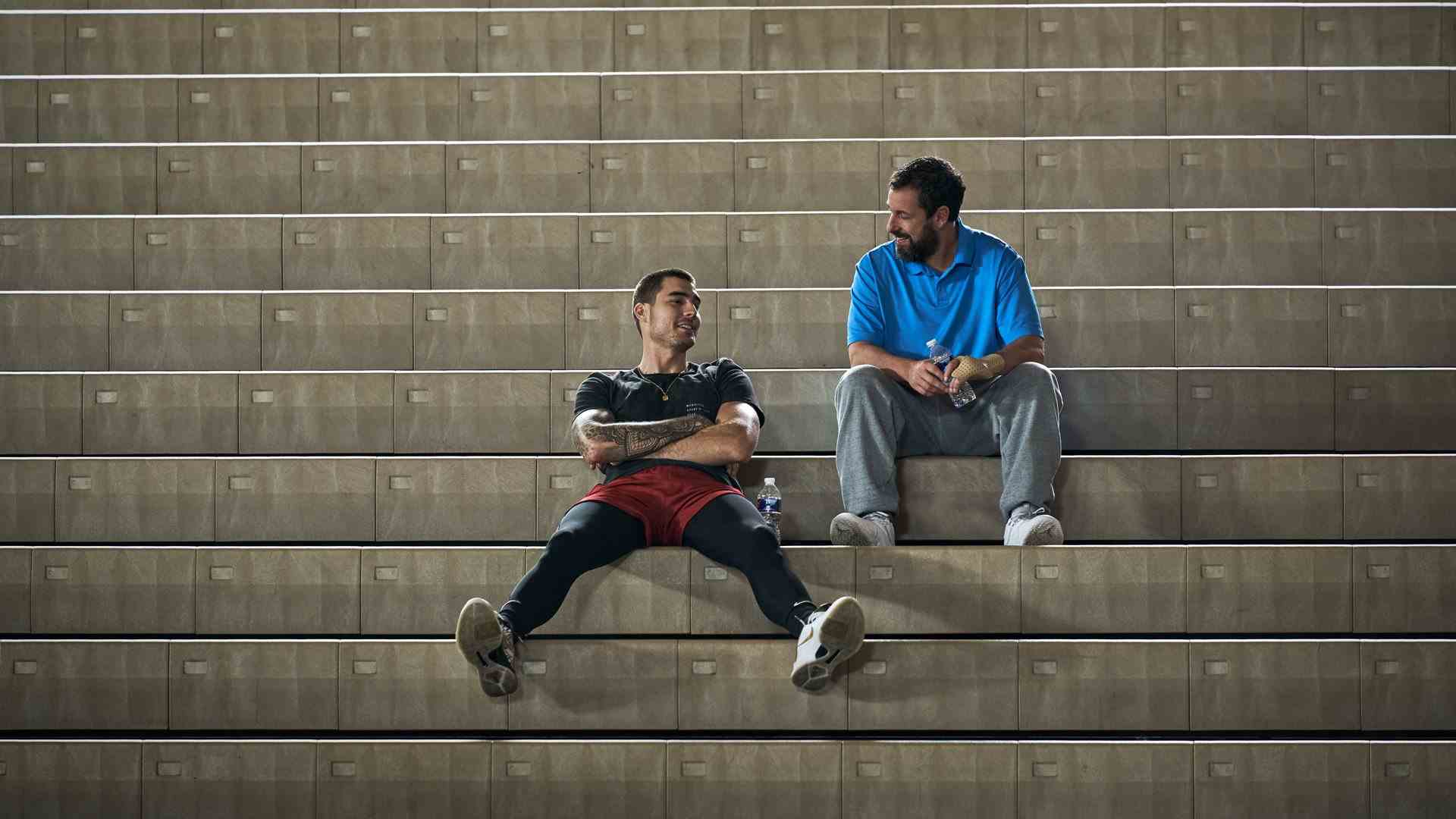 Deux hommes sont assis dans un stand de basket.