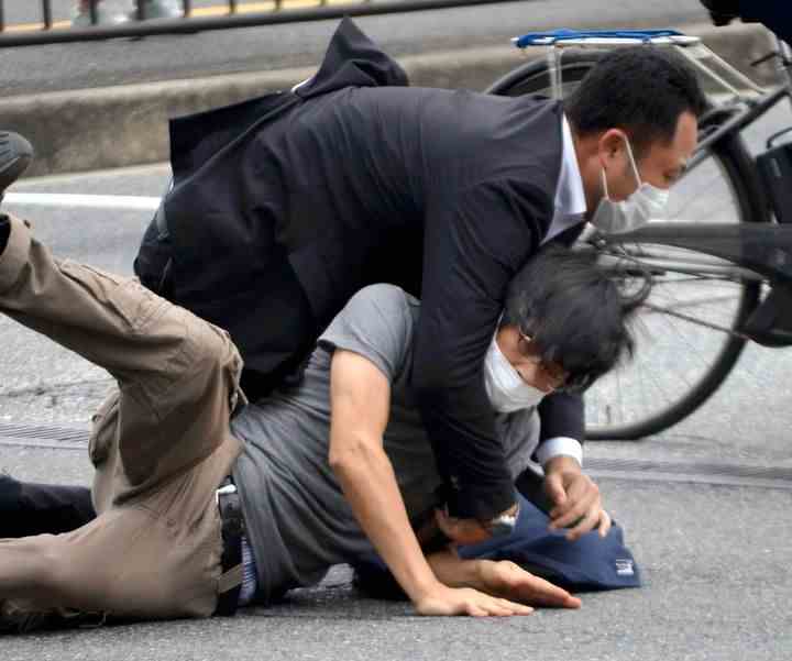 Tetsuya Yamagami, ci-dessous, est arrêté près du site de tir dans la préfecture de Nara, dans l'ouest du Japon, le 8 juillet 2022.