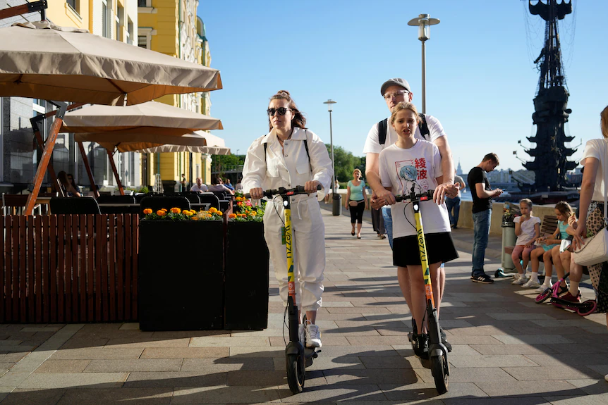 Les gens conduisent des scooters électriques de location