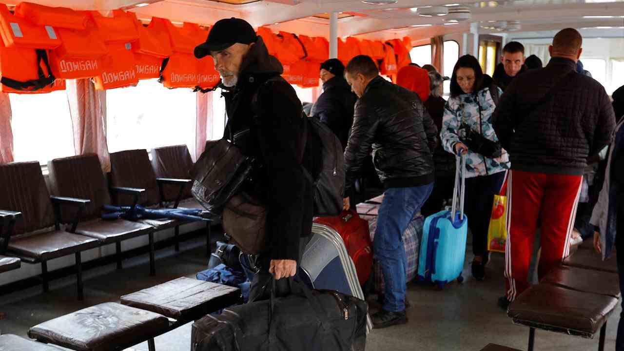 Les citoyens cherchent une place sur le ferry qui les emmène hors de Kherson.