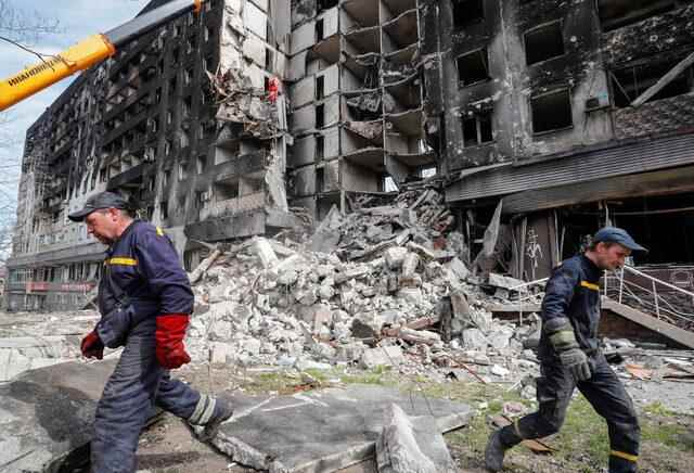 Emergency workers remove debris of a building destroyed in the course of the Ukraine-Russia conflict, in Mariupol