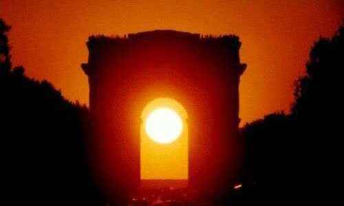 The Sun sets in the axis of the Arc de